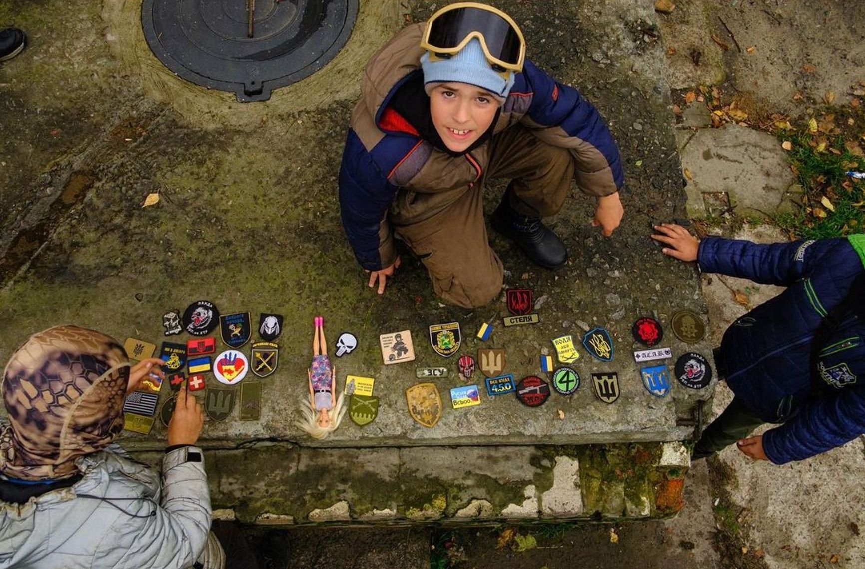 The boy called David (wearing protective goggles) exchanging military badges with his friends at the “checkpoint”