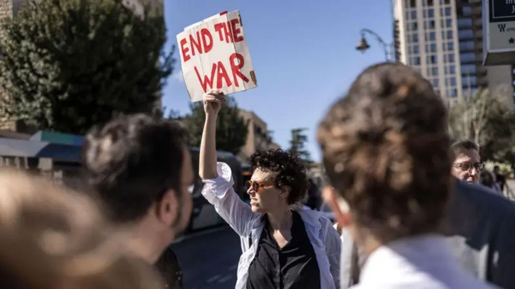 An Israeli protester in Jerusalem holds a banner calling on the government to end the war.
